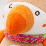 Pormenor da textura macia e dos acabamentos de qualidade do peluche de pássaro.