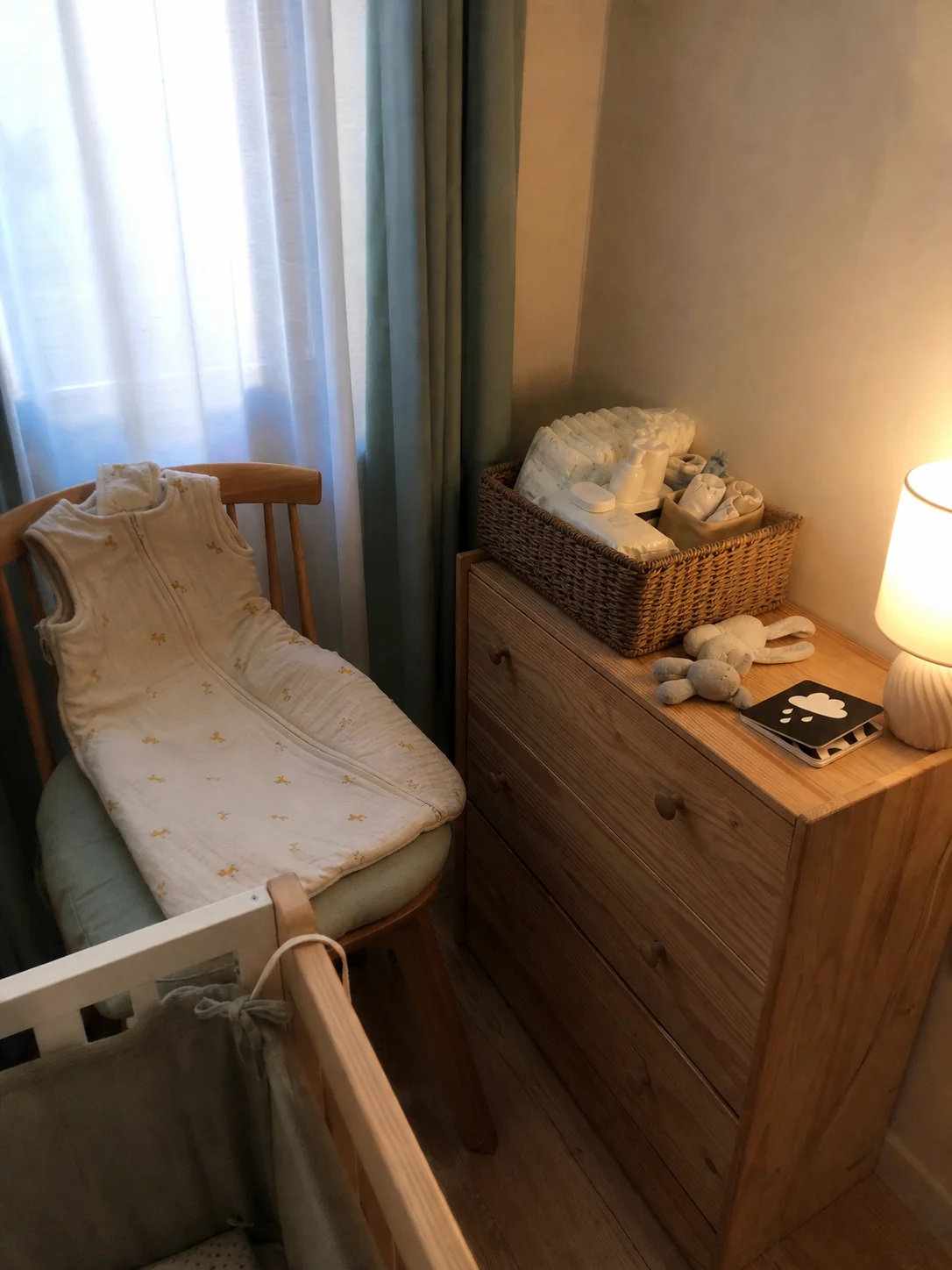 Canto de quarto de bebé com saco de dormir, livro e luz suave